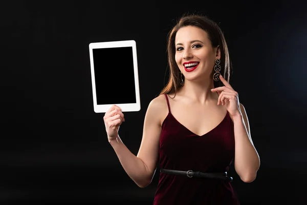 Donna sorridente in abito con tablet digitale su sfondo nero — Foto stock