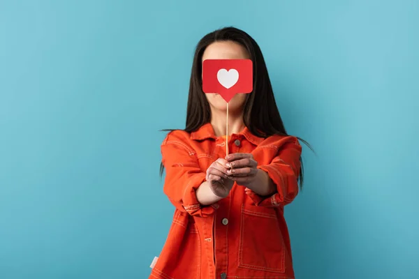 Frau verdeckt Gesicht mit Stock mit Papier wie auf blauem Hintergrund — Stockfoto