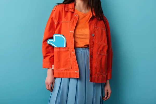 Cropped view of woman with paper like in jacket on blue background — Stock Photo