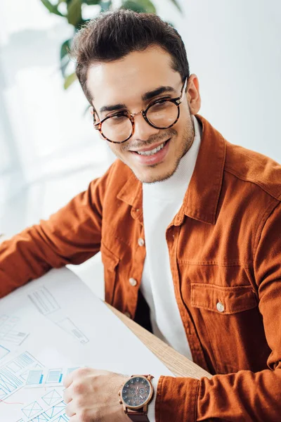 Smiling developer looking away while planning user experience design at table in office — Stock Photo