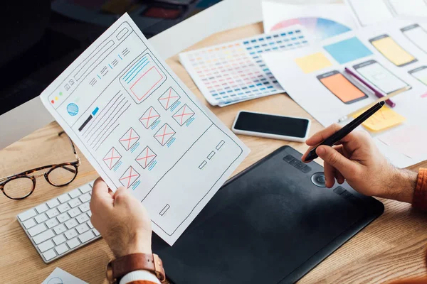 Cropped view of designer using graphics tablet while planning user experience design of website at table — Stock Photo