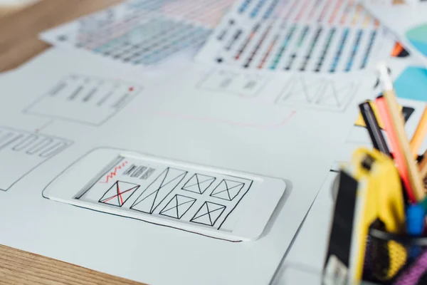 Selective focus of layouts of user experience design sketches and stationery on table — Stock Photo