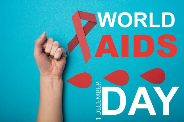 Top view of paper drops of blood near female hand on blue background, world aids day illustration — Stock Photo