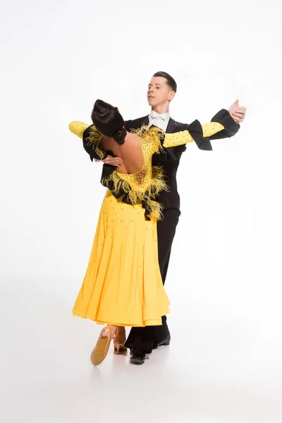 Elegante joven pareja de bailarines de salón bailando aislados en blanco - foto de stock