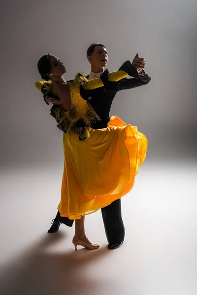 Elegant young couple of ballroom dancers dancing in dark — Stock Photo