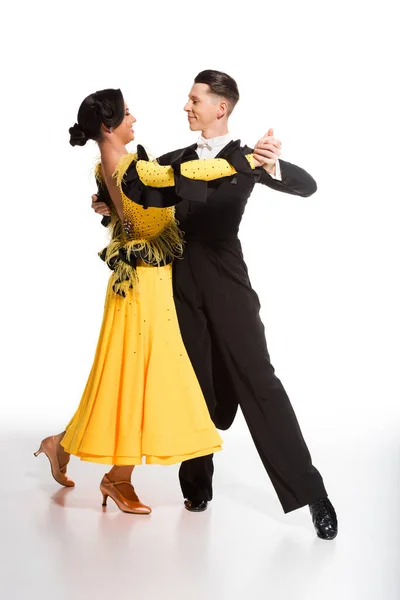 Elegant young couple of ballroom dancers dancing on white — Stock Photo