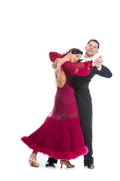 Elegant young couple of ballroom dancers in red dress in suit dancing on white — Stock Photo