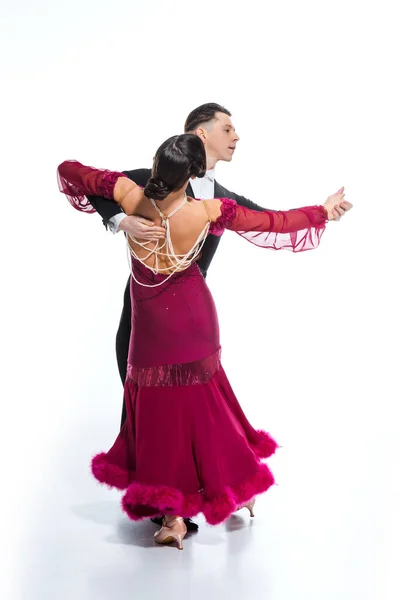 Élégant jeune couple de danseurs de salon en robe rouge en costume dansant sur blanc — Photo de stock