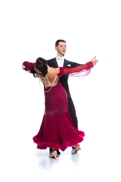 Élégant jeune couple de danseurs de salon en robe rouge en costume dansant sur blanc — Photo de stock