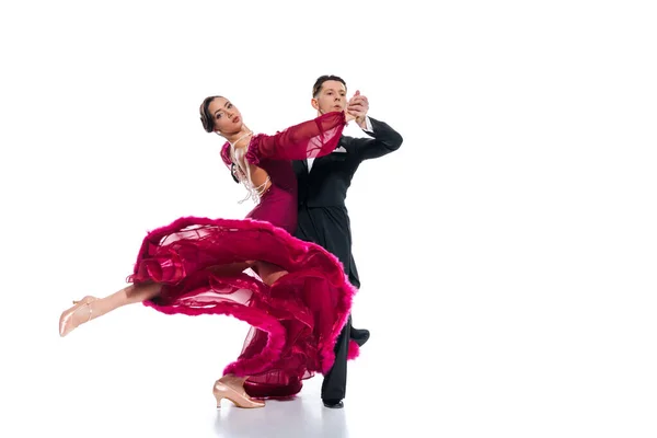 Elegant young couple of ballroom dancers in red dress in suit dancing on white — Stock Photo