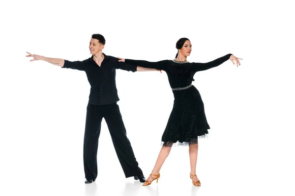 Элегантная молодая пара танцовщиц в черном платье и костюме, танцующих изолированно на белом — стоковое фото