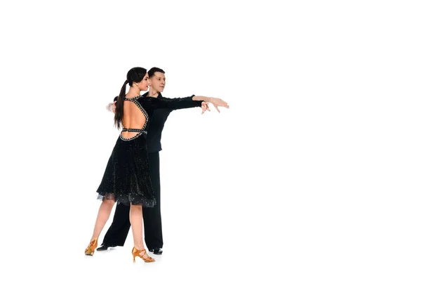 Elegante jovem casal de dançarinos de salão em vestido preto e terno dançando isolado no branco — Fotografia de Stock