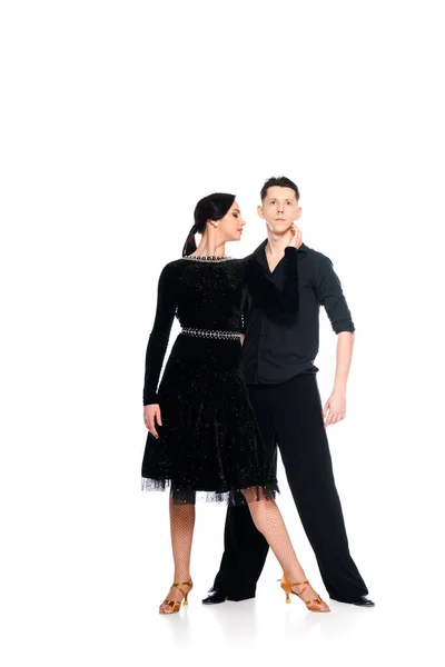 Elegant young couple of ballroom dancers in black dress and suit dancing isolated on white — Stock Photo