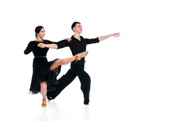 Élégant jeune couple de danseurs de salon en robe noire et costume danse isolé sur blanc — Photo de stock