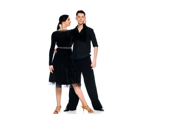 Элегантная молодая пара танцовщиц в черном платье и костюме, танцующих изолированно на белом — стоковое фото