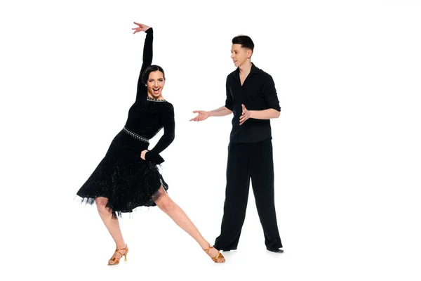 Élégant jeune couple de danseurs de salon en robe noire et costume danse isolé sur blanc — Photo de stock