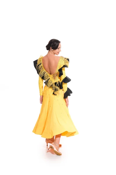 Vista posteriore di elegante giovane ballerina sala da ballo in abito giallo ballare isolato su bianco — Foto stock