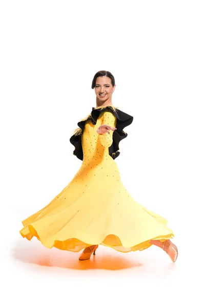 Sonriente elegante joven bailarina de salón en vestido amarillo bailando sobre blanco - foto de stock