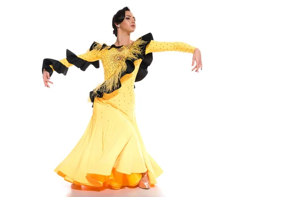 Елегантна молода бальна танцівниця в жовтій сукні танцює на білому — стокове фото