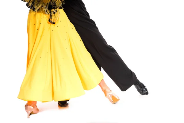 Cropped view of elegant young couple of ballroom dancers in yellow dress and black suit dancing isolated on white — Stock Photo