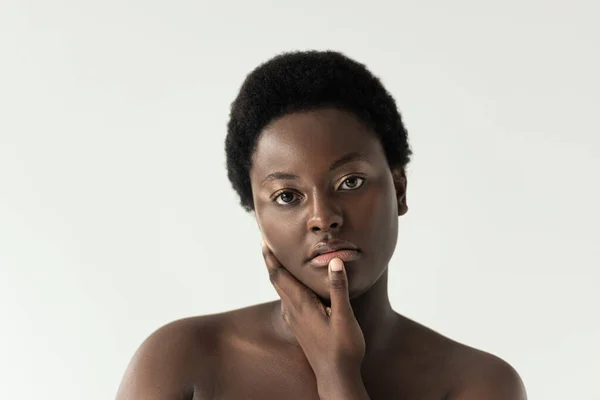 Belle nu afro-américaine femme touchante visage isolé sur gris — Photo de stock