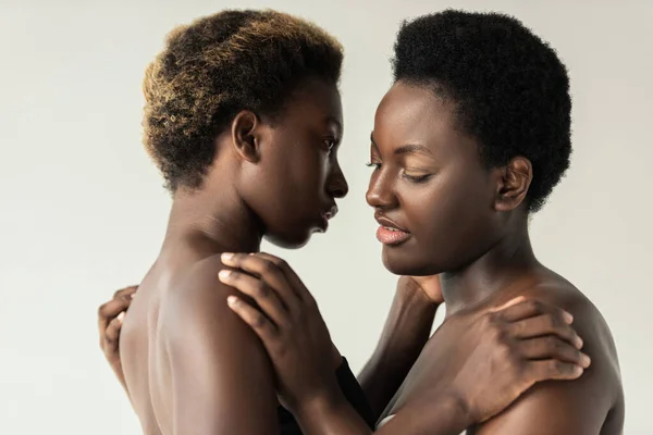 Mujeres afroamericanas desnudas abrazándose aisladas en gris - foto de stock