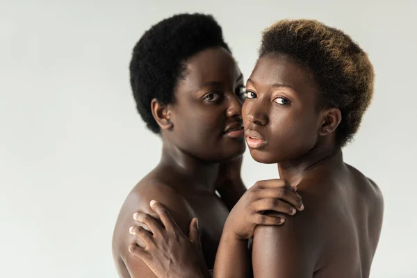Оголені афроамериканські жінки обіймаються ізольовано на сірому — стокове фото