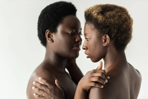 Tenera donne africane americane nude che si abbracciano isolate sul grigio — Foto stock