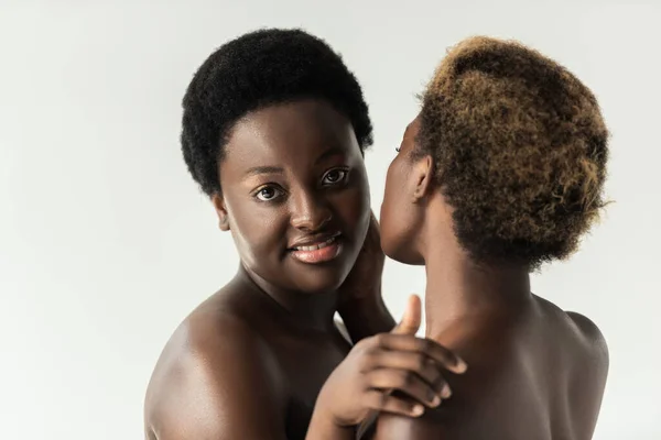 Chicas afroamericanas desnudas positivas abrazándose aisladas en gris - foto de stock