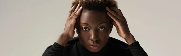 Plan panoramique d'une jolie femme afro-américaine au col roulé noir isolé sur fond gris — Photo de stock