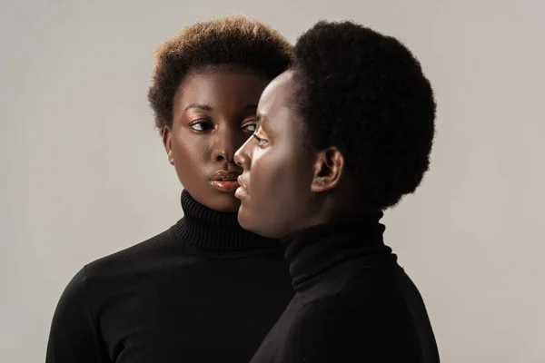 Retrato de mulheres africanas americanas em golas pretas isoladas em cinza — Fotografia de Stock