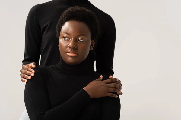 Amis afro-américains à col roulé noir tenant les mains isolées sur gris — Photo de stock