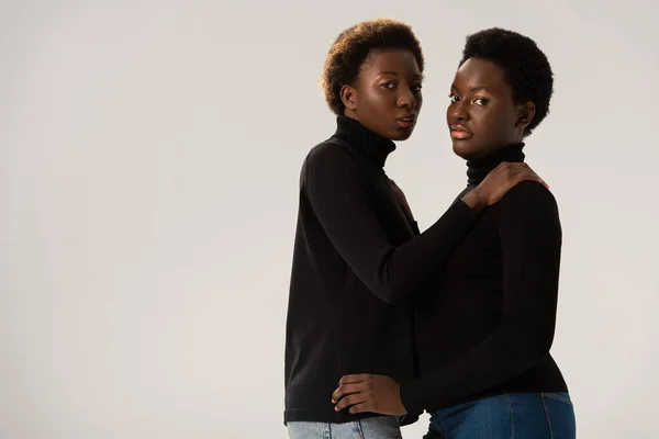 Afro americano fidanzate in nero dolcevita abbracci isolato su grigio — Foto stock