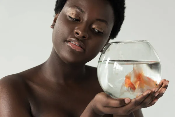 Tender nude african american girl holding aquarium with fish isolated on grey — Stock Photo