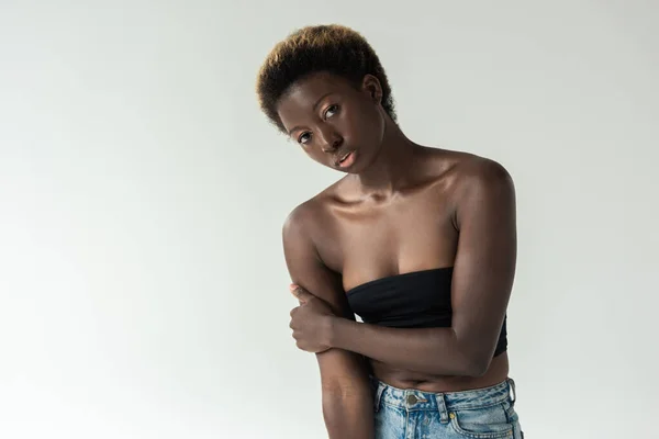 Menina americana africana atraente em jeans e top preto isolado em cinza — Fotografia de Stock