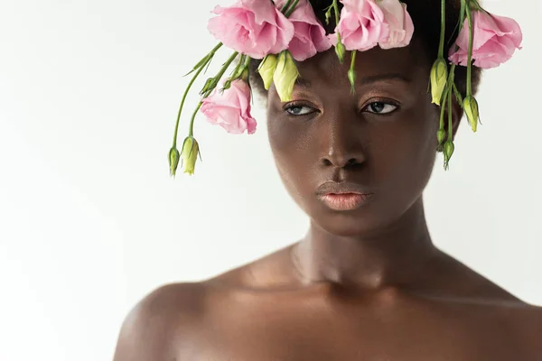 Hermosa mujer afroamericana desnuda con flores de eustoma rosa aisladas en gris - foto de stock