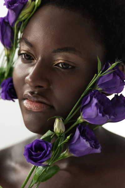 Bella donna africana americana nuda con fiori di eustoma viola isolati su bianco — Foto stock