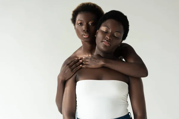 Афроамериканські жінки зверху обіймаються ізольовано на сірому — стокове фото