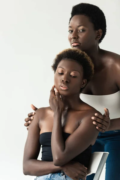 Atractivo tierno afroamericano niñas en tapas aisladas en gris - foto de stock