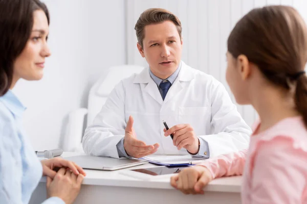 Selective focus of ent physician talking to mother and daughter during consultation — Stock Photo