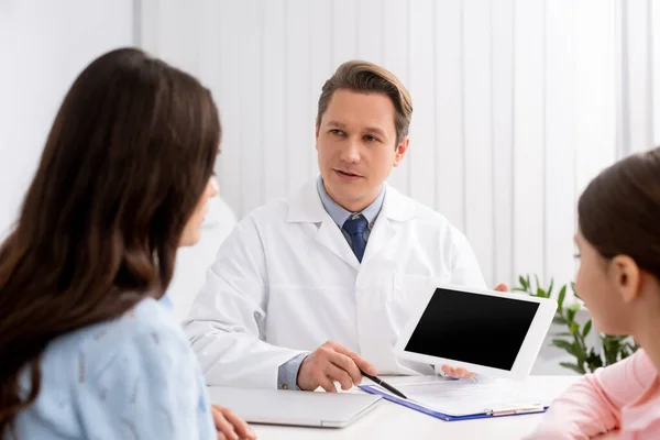 Back view of mother and daughter near otolaryngologist holding digital tablet with blank screen — Stock Photo