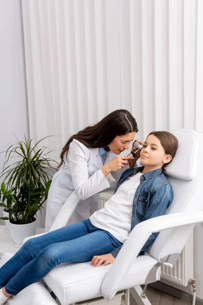 Otolaryngologue attentif examinant l'oreille d'un enfant adorable avec otoscope — Photo de stock