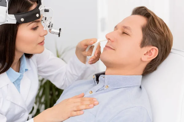 Beau, attrayant otolaryngologue en phare ent examen nez du patient avec spéculum nasal — Photo de stock