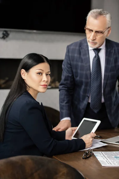 Foyer sélectif de femme d'affaires asiatique avec tablette numérique et homme d'affaires sur fond — Photo de stock