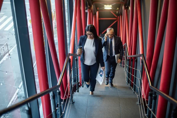 Geschäftsmann mit Smartphone und asiatische Geschäftsfrau mit Pappbecher auf Treppe — Stockfoto