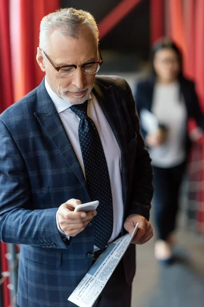Bell'uomo d'affari in giacca e cravatta con giornale e smartphone — Foto stock