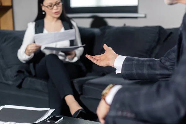 Recortado vista de hombre de negocios hablando con asiático businesswoman - foto de stock