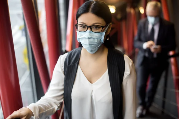 Азиатская деловая женщина в формальной одежде в медицинской маске смотрит в сторону — стоковое фото