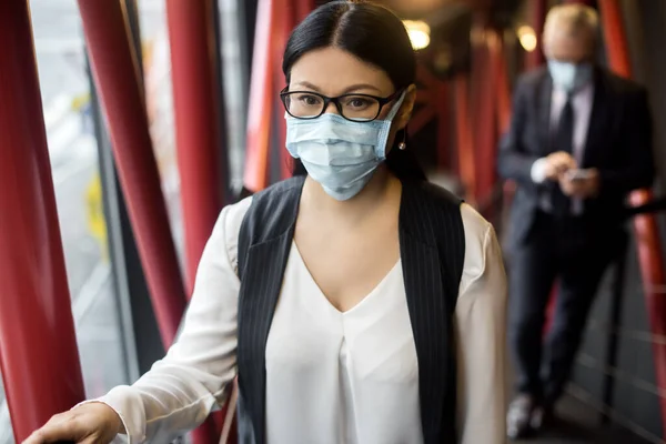 Asiatische Geschäftsfrau in formeller Kleidung mit medizinischer Maske, die wegschaut — Stockfoto