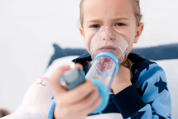 Selektiver Fokus des asthmatischen Kindes mittels Inhalator mit Abstandhalter — Stockfoto